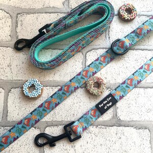 May include: A turquoise dog lead featuring a repeating pattern of sea creatures, including crabs and starfish. The lead has a black clasp and a matching handle. The text "Fur the Love of Toys" is visible. Two dog treats are also in the image.