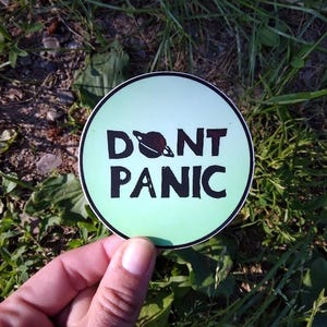 Vinylklistermärke "Don't Panic" - Liftarens guide till galaxen - 7,5 cm runt grönt klistermärke - Blocktryck - H2G2 - Gåva för sci-fi-fans