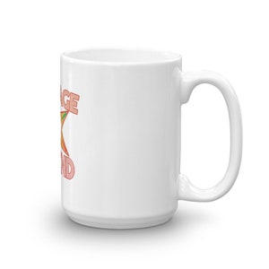 Pode incluir: Caneca de cer&acirc;mica branca com uma estrela rosa e laranja e o texto "Orange you glad" impresso no lado.