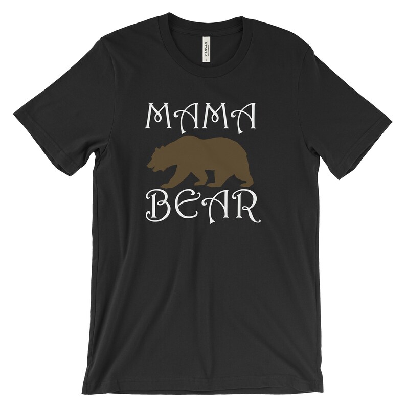 以下が含まれることがあります： 黒いTシャツに白い文字で「ママベア」と書いてあり、茶色の熊のシルエットが描かれている。
