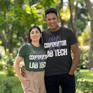 May include: Two people wearing matching green and black t-shirts with the text "Chaos Coordinator AKA Lab Tech" in white and purple. The couple is standing in a grassy area with trees in the background.