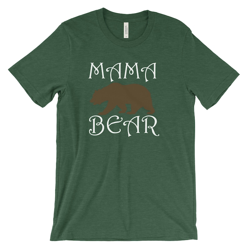 以下が含まれることがあります： 白い文字で「MAMA BEAR」と書いてある緑色の半袖Tシャツ。茶色の熊のシルエットが描かれている。