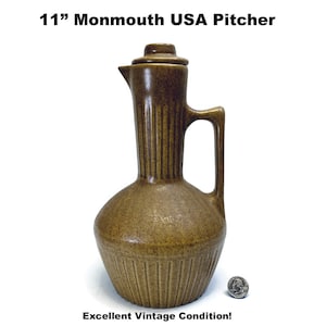 May include: A brown ceramic Monmouth USA pitcher with a lid and handle. The pitcher is 11 inches tall and has vertical ribbed detailing. The words "11" Monmouth USA Pitcher" and "Excellent Vintage Condition!" are printed on the image.