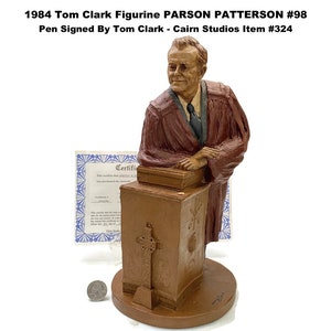 May include: A brown figurine of Parson Patterson, #98, from 1984, signed by Tom Clark. The figurine depicts a man in a robe, standing behind a podium with a cross. The text on the image reads "1984 Tom Clark Figurine PARSON PATTERSON #98".