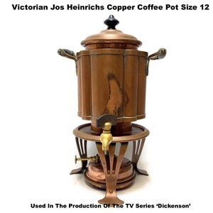 May include: A Victorian Jos Heinrichs copper coffee pot, size 12, with a brass spigot and black handle accents. The antique coffee pot has a decorative design and is used in the TV series 'Dickenson'.