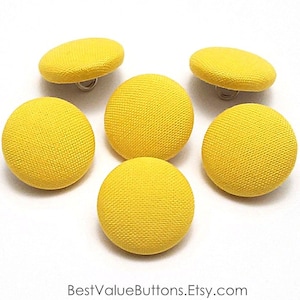 May include: Six yellow fabric covered buttons with a shank attachment.