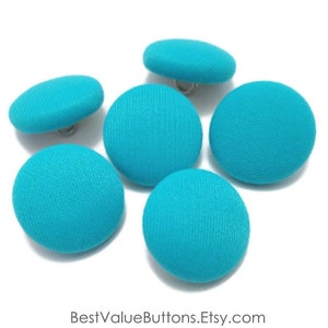 May include: Six turquoise fabric covered buttons with silver shanks.