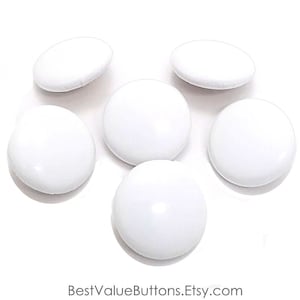 May include: Six white round buttons, each with a smooth, glossy finish.