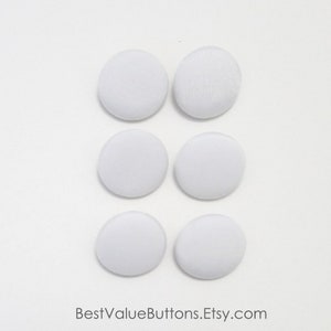 May include: Six white, fabric-covered buttons arranged in two columns of three. The buttons are round and have a slightly textured surface. The Etsy shop name, BestValueButtons.Etsy.com, is printed at the bottom.