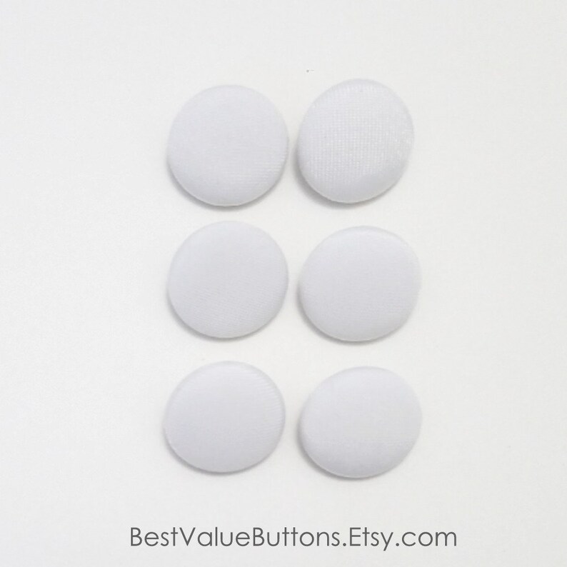 May include: Six white, fabric-covered buttons arranged in two columns of three. The buttons are round and have a slightly textured surface. The Etsy shop name, BestValueButtons.Etsy.com, is printed at the bottom.
