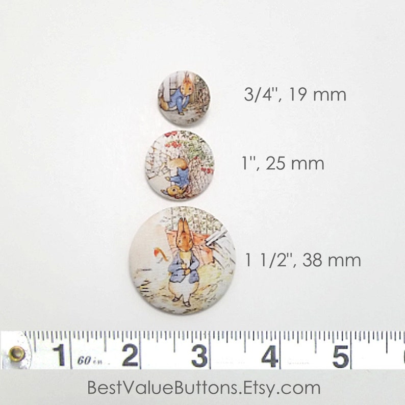 May include: Three round fabric buttons with a Peter Rabbit design. The buttons are 3/4 inch, 1 inch, and 1 1/2 inches in diameter.