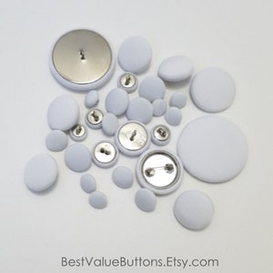 May include: An assortment of white fabric-covered buttons in various sizes, including pin-back buttons. The buttons are arranged on a white surface. The text "BestValueButtons.Etsy.com" is at the bottom.