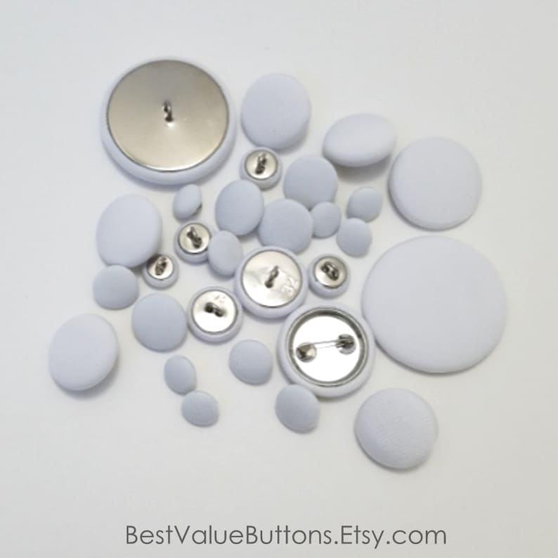 May include: An assortment of white fabric-covered buttons in various sizes, including pin-back buttons. The buttons are arranged on a white surface. The text "BestValueButtons.Etsy.com" is at the bottom.
