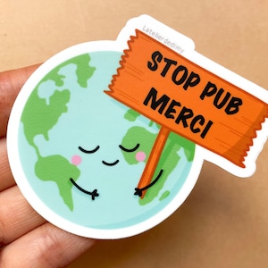 Peut inclure: Une illustration de dessin animé de la Terre tenant un panneau qui dit "Stop Pub Merci". La Terre est bleue et verte avec un visage souriant et les yeux fermés.