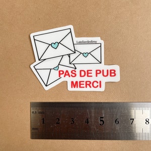 Le stop pub est posé à côté d’une règle. Il mesure environ 6 cm de longueur.