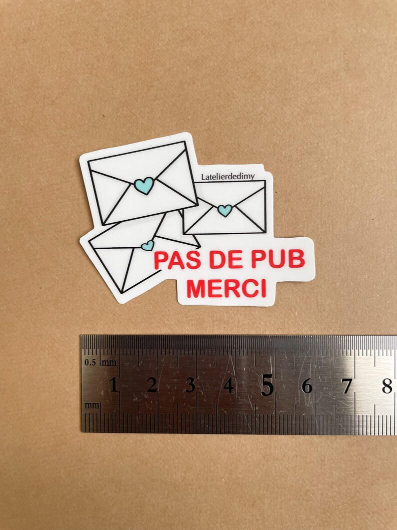 Le stop pub est posé à côté d’une règle. Il mesure environ 6 cm de longueur.