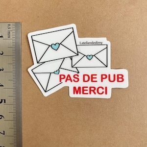 Le stop pub est posé à côté d’une règle. Il mesure environ 4,5 cm de hauteur.