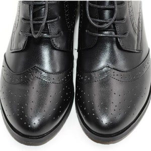 May include: Black leather lace-up shoes with a brogue design and a round toe.