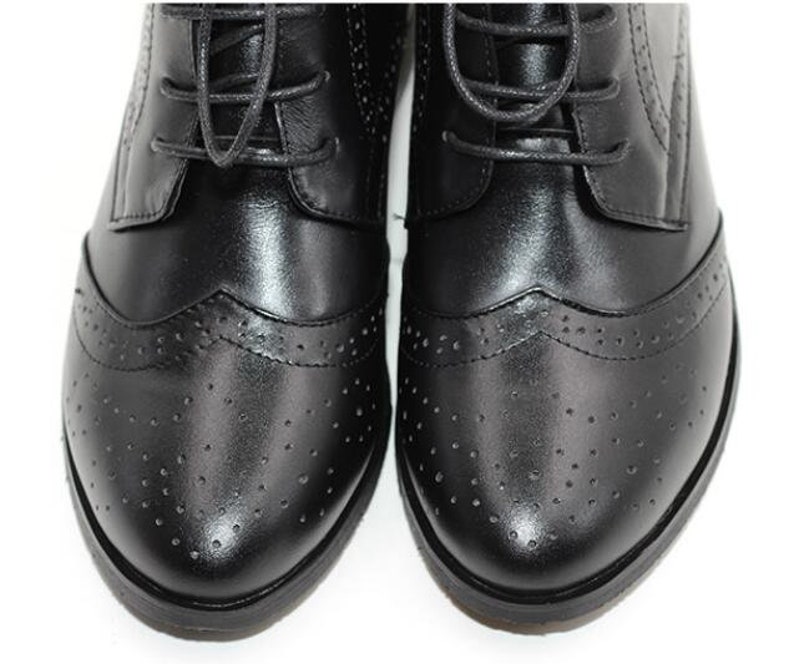 May include: Black leather lace-up shoes with a brogue design and a round toe.