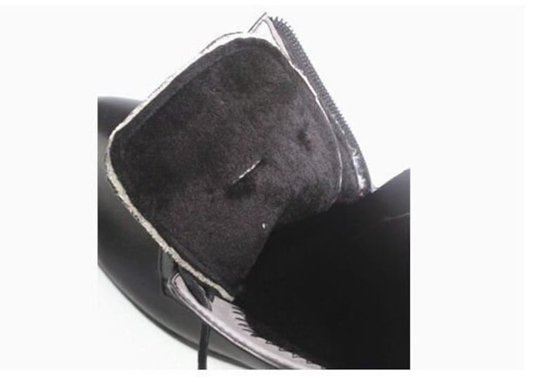 May include: Close-up of the inside of a black leather boot with a soft, black lining. The boot has a zipper on the side.