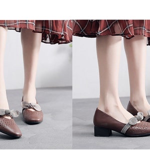 Puede incluir: Zapatos de cuero marr&oacute;n con un peque&ntilde;o lazo y un tac&oacute;n bajo de bloque. Los zapatos tienen un dise&ntilde;o perforado y los lleva una modelo con una falda de cuadros.