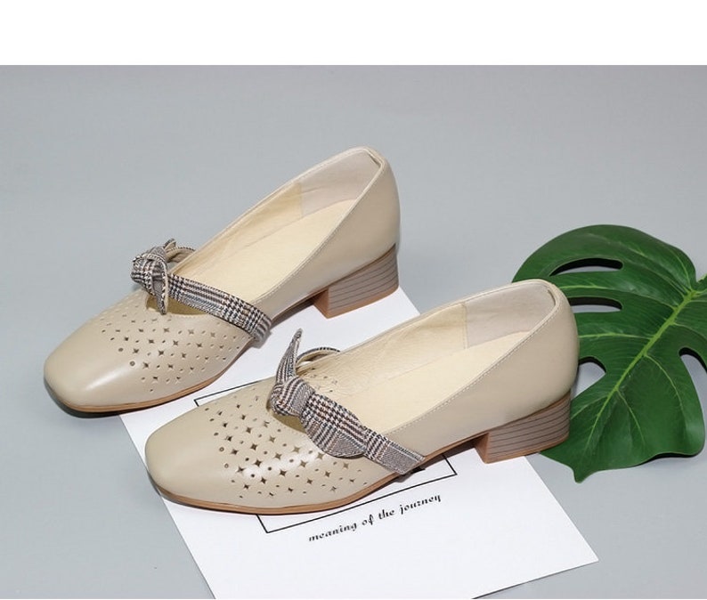 Puede incluir: Zapatos de cuero beige con tac&oacute;n bajo de bloque y detalle de lazo de cuadros. Los zapatos tienen un dise&ntilde;o de corte y son perfectos para la primavera y el verano.
