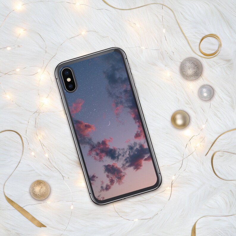 May include: A black phone case with a pink and purple cloudy sky with stars and a crescent moon printed on it.