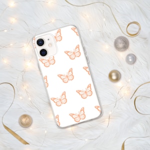 Puede incluir: Una funda transparente para tel&eacute;fono con fondo blanco y un patr&oacute;n repetido de mariposas de color melocot&oacute;n.