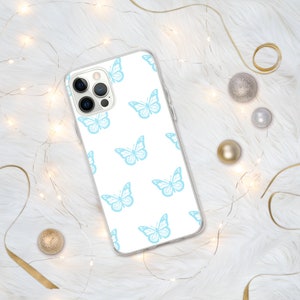 Puede incluir: Una funda de tel&eacute;fono transparente con fondo blanco y un patr&oacute;n repetitivo de mariposas de color azul claro.