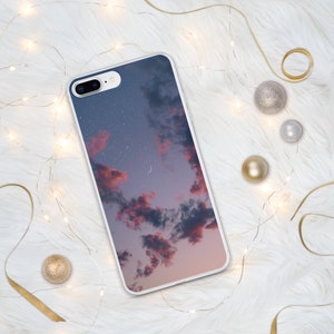 May include: A white phone case with a pink and blue sky with clouds and stars printed on it.