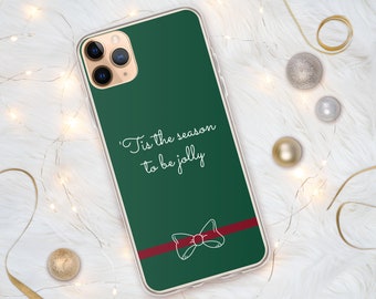 May include: A green phone case with a white bow and red ribbon. The text "'Tis the season to be jolly" is printed on the case.