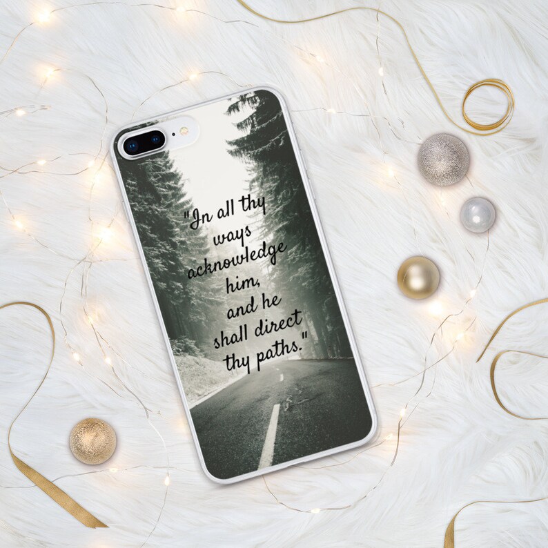 Op de afbeelding: Een witte telefoonhoes met een zwart-witfoto van een weg door een bos. De tekst "In all thy ways acknowledge him, and he shall direct thy paths." staat op de hoes gedrukt.
