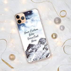 May include: A clear phone case with a snowy mountain scene and a blue sky with clouds. The text "Your Custom Bible Verse/Text Here" is printed on the case.