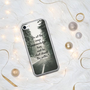 Op de afbeelding: Een transparante telefoonhoes met een zwart-witfoto van een besneeuwde weg met bomen aan weerszijden. De tekst "In all thy ways acknowledge him, and he shall direct thy paths." staat op de hoes gedrukt.