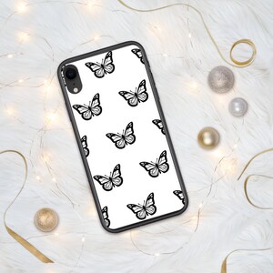 Puede incluir: Una funda de tel&eacute;fono negra con fondo blanco y un patr&oacute;n repetitivo de mariposas negras.