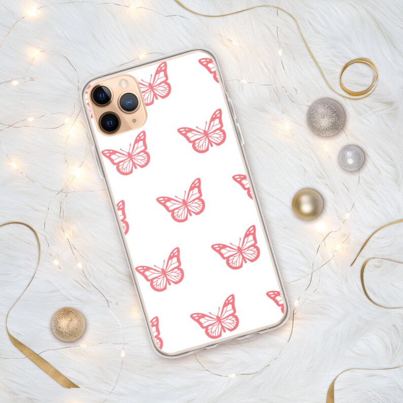 Puede incluir: Una funda de tel&eacute;fono transparente con fondo blanco y un patr&oacute;n de mariposas rosas.