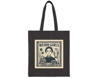 May include: A black tote bag featuring a cream-colored square graphic with the text WEIRD GIRLS CLUB. The illustration depicts a person with dark hair, a hairless cat, stacks of books, and flowers, all enclosed within a decorative border.