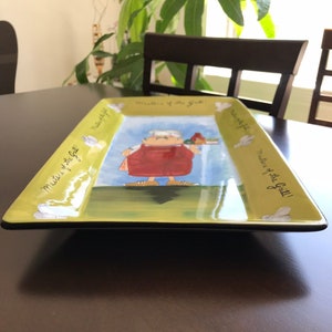 Puede incluir: Una fuente rectangular verde con borde negro. La fuente presenta una ilustración de dibujos animados de una persona sosteniendo una bandeja de comida. El texto "Mistress of the Grill!" está escrito en la fuente.
