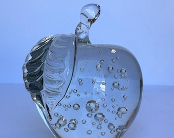 Könnte beinhalten: Eine klare Glasskulptur in Form eines Apfels mit einem Blattdetail und vielen kleinen Luftblasen.