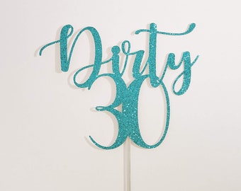 Puede incluir: Topper para pastel de purpurina turquesa con las palabras "Dirty 30" en una fuente cursiva.