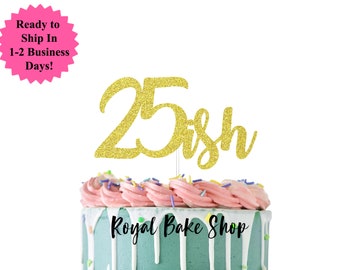 Könnte beinhalten: Goldener Glitzer-Kuchentopper mit der Zahl 25 und dem Wort "ish" in Kursivschrift. Der Topper befindet sich auf einem rosa und grün glasierten Kuchen mit den Worten "Royal Bake Shop" in Schwarz.