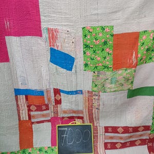 Puede incluir: Una colcha de retazos con una variedad de colores y patrones, incluyendo rosa, rojo, verde, azul y blanco. La colcha est&aacute; hecha de diferentes telas y texturas, y tiene un aspecto r&uacute;stico y hecho a mano. Un peque&ntilde;o letrero de pizarra con el precio "7000" est&aacute; en la esquina inferior derecha de la imagen.