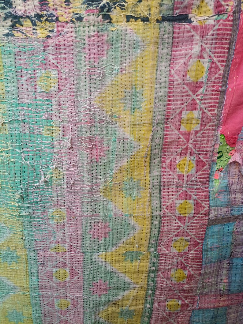 Puede incluir: Una colcha de retazos colorida con una variedad de patrones geom&eacute;tricos en tonos de rosa, amarillo, verde y azul. La colcha est&aacute; hecha de diferentes telas cosidas juntas, creando una superficie &uacute;nica y texturizada.