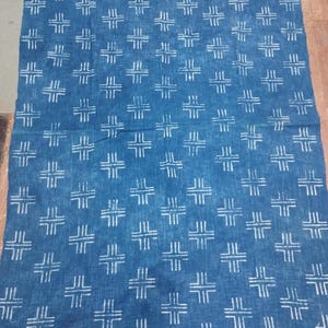 May include: A blue cotton fabric with a white geometric pattern. The fabric has a fringed border.