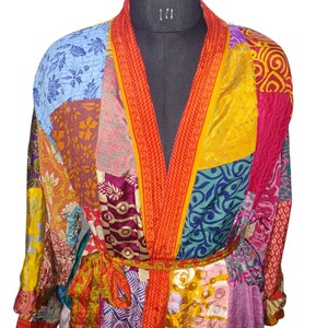 May include: A colorful patchwork robe with a red and yellow trim. The robe has a long sleeve and a tie belt.