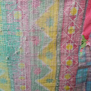 Puede incluir: Una colcha de retazos colorida con una variedad de patrones geom&eacute;tricos en tonos de rosa, amarillo, verde y azul. La colcha est&aacute; hecha de diferentes telas cosidas juntas, creando una superficie &uacute;nica y texturizada.