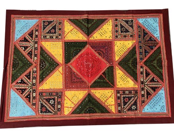 May include: A colorful patchwork quilt with a geometric design. The quilt is made of various fabrics in shades of red, yellow, green, blue, and brown. The quilt is decorated with sequins and mirror work.