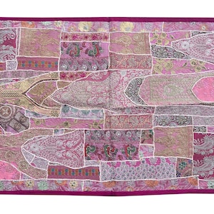 May include: A pink and white patchwork throw pillow with a floral design. The pillow is made of various fabrics and has a pink border.