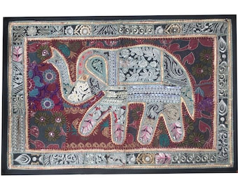 May include: A colorful patchwork elephant wall hanging with a maroon background and silver embroidery. The elephant is made of different fabrics and textures, creating a unique and eye-catching design.