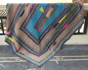 Puede incluir: Una colcha kantha multicolor con un patrón de rayas azules, marrones y rosas. La colcha está hecha de saris reciclados y tiene un diseño de patchwork.